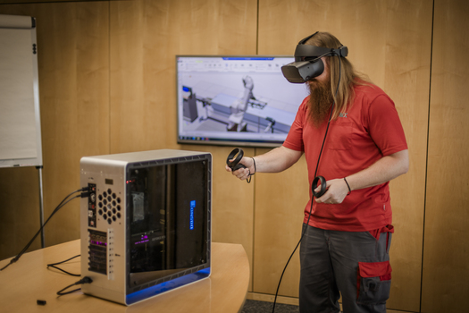 Mann mit VR Brille und Contollern vor Computer.jpg